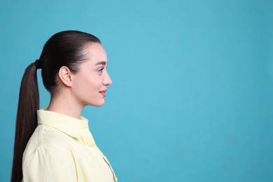 Photo of Profile portrait of young woman on light blue background. Space for text