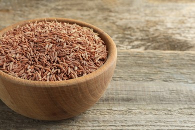 Bowl of caraway seeds on wooden table, closeup. Space for text