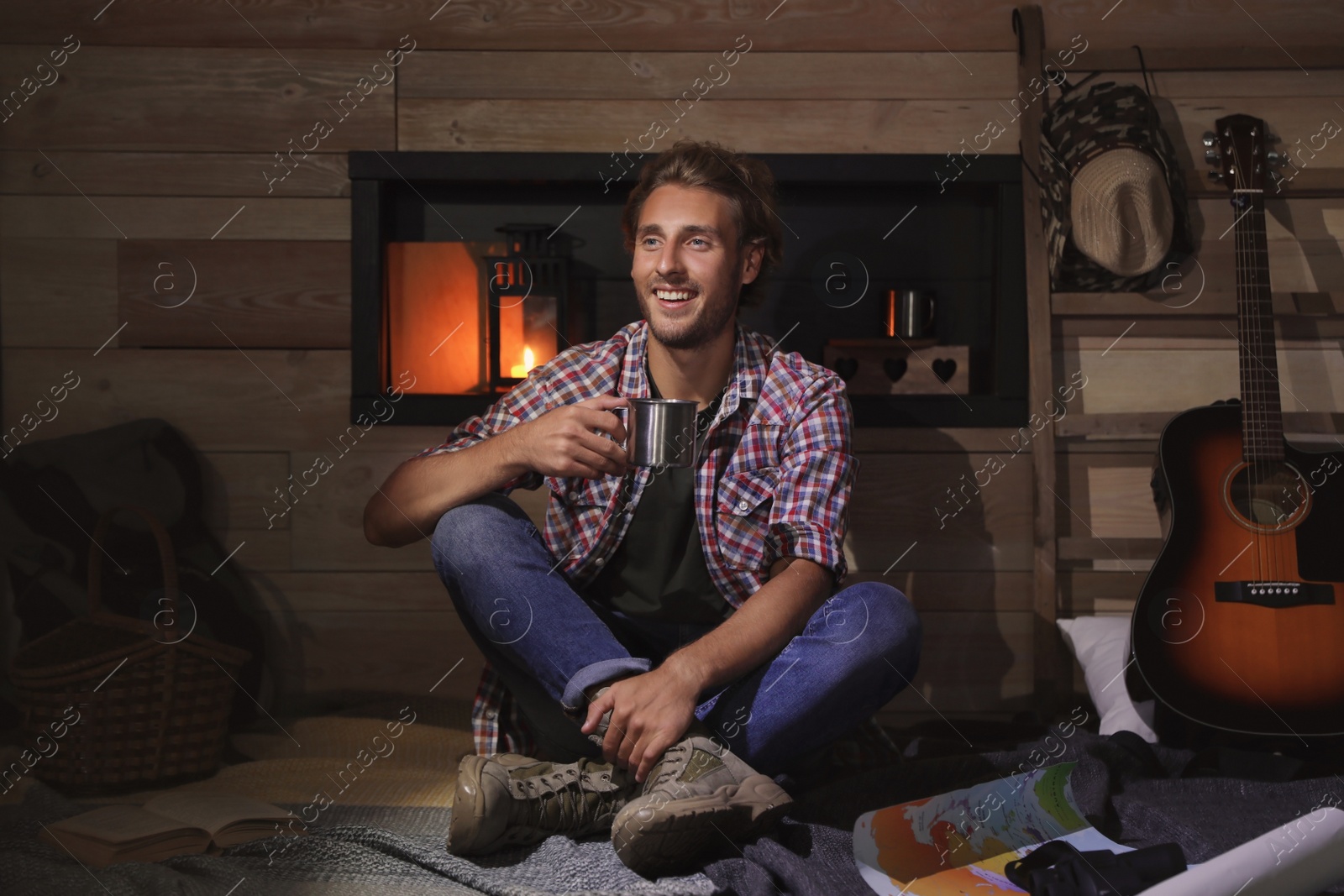 Photo of Handsome young traveler with mug indoors