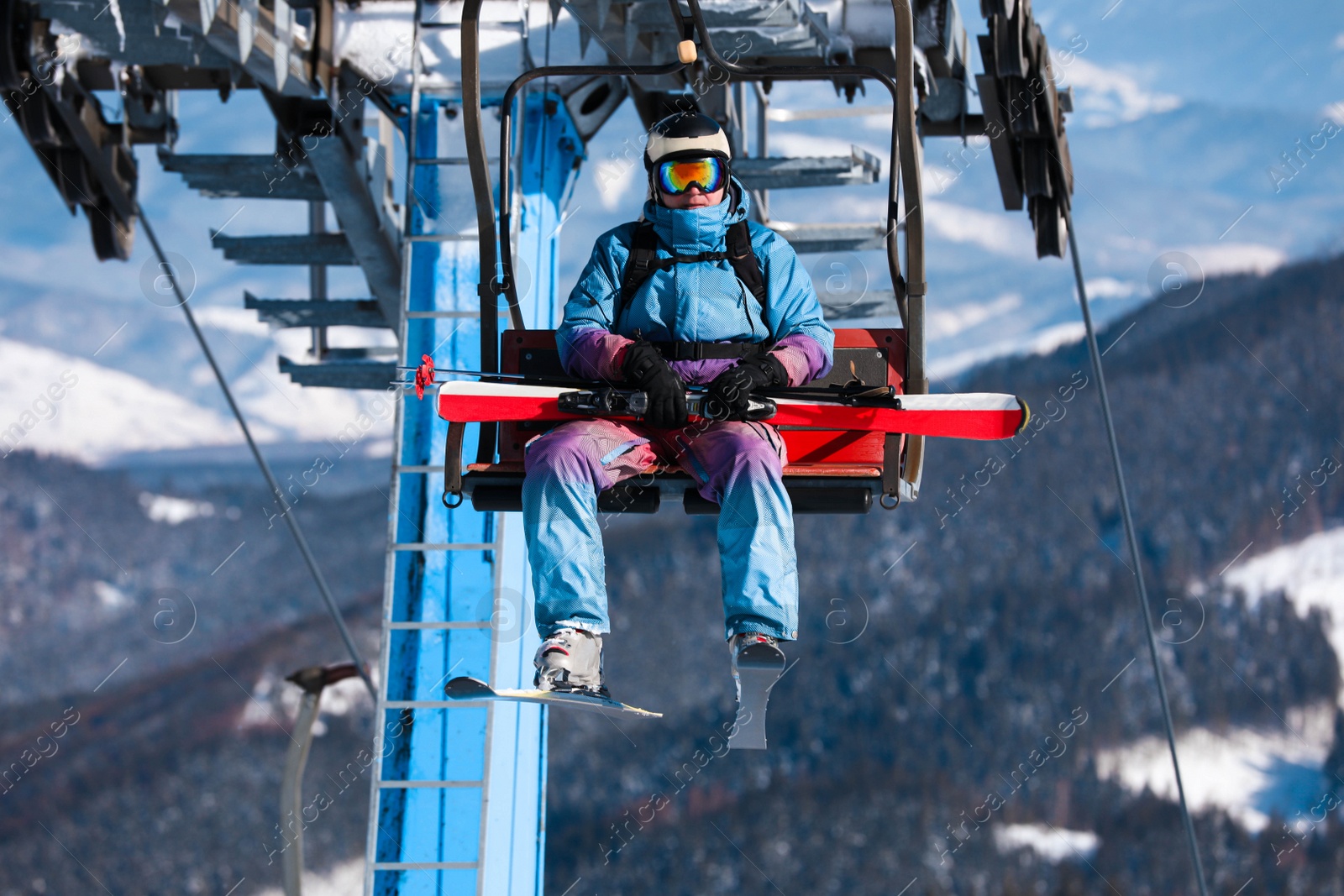 Photo of Man using chairlift at mountain ski resort. Winter vacation