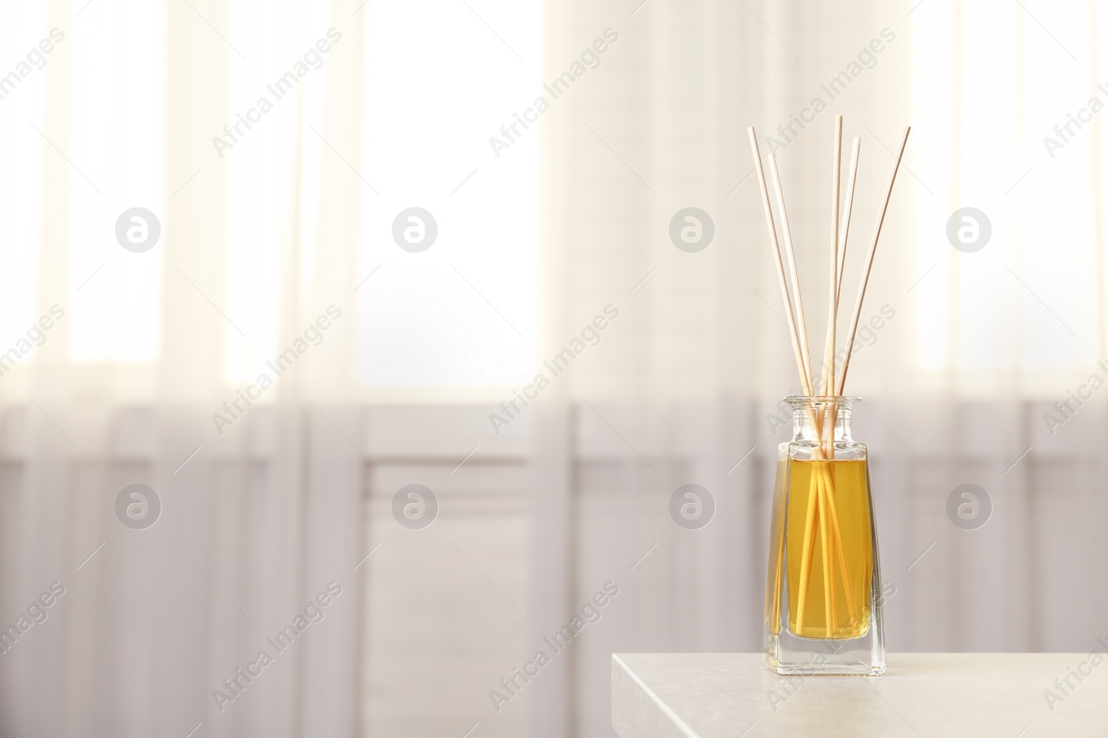 Photo of Reed air freshener on table indoors, space for text