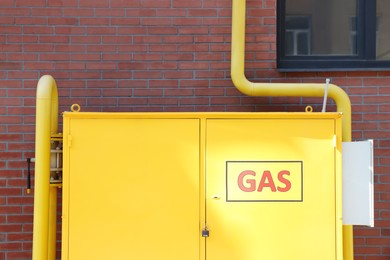 Gas distribution system with pipes near red brick wall outdoors