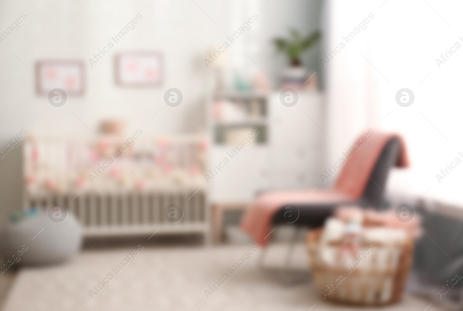 Photo of Blurred view of baby room interior  with comfortable crib