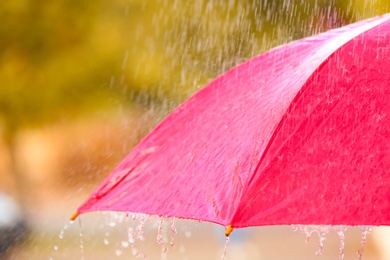 Photo of Bright color umbrella under rain outdoors, closeup