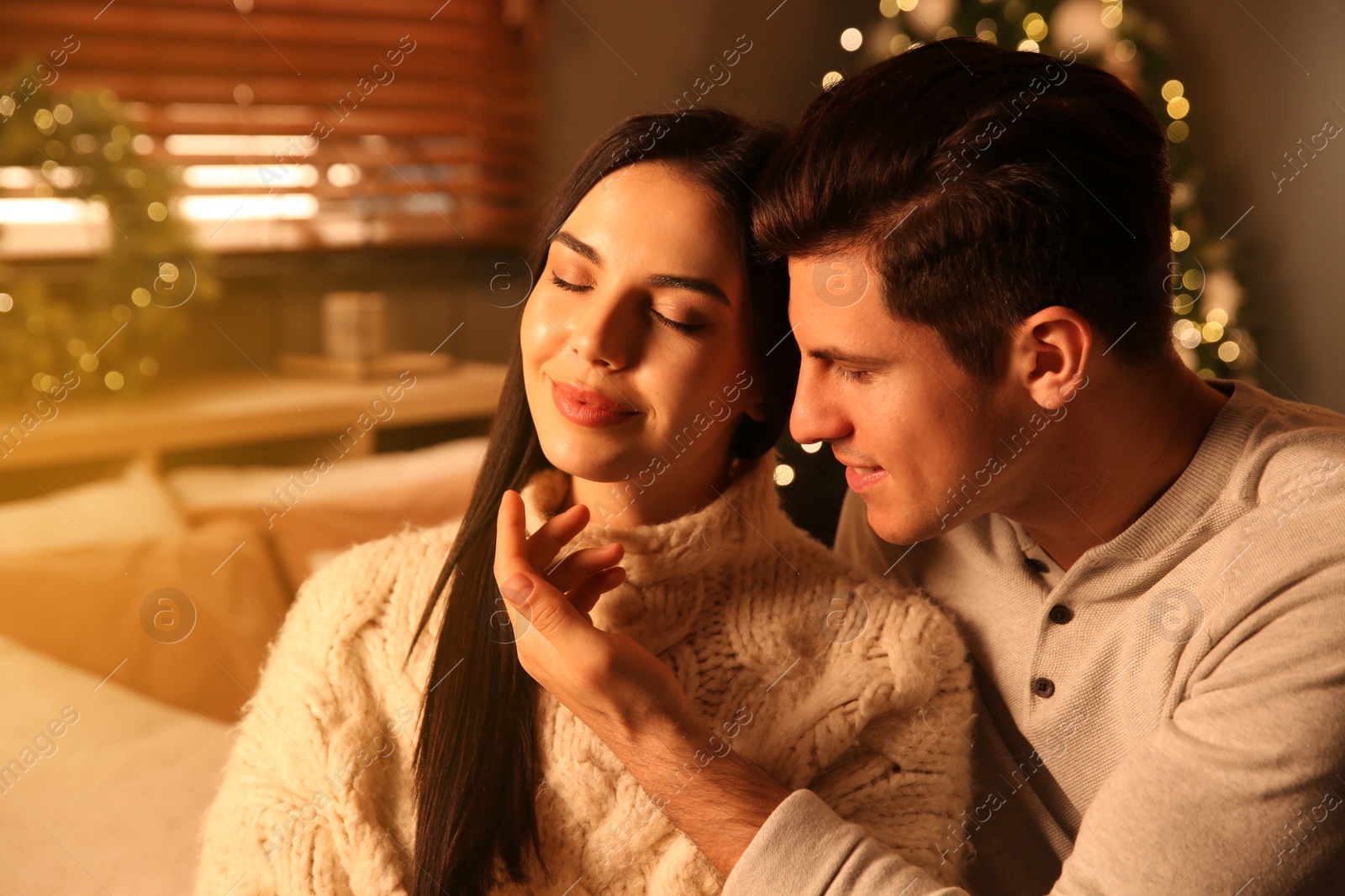 Photo of Happy couple in festively decorated room. Christmas celebration