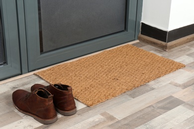 Photo of New clean mat and shoes near entrance door