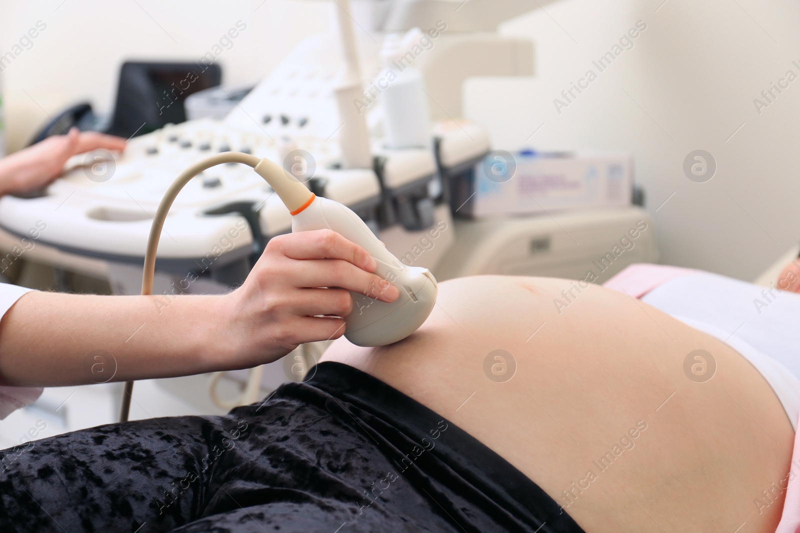 Photo of Pregnant woman undergoing ultrasound scan in clinic, closeup