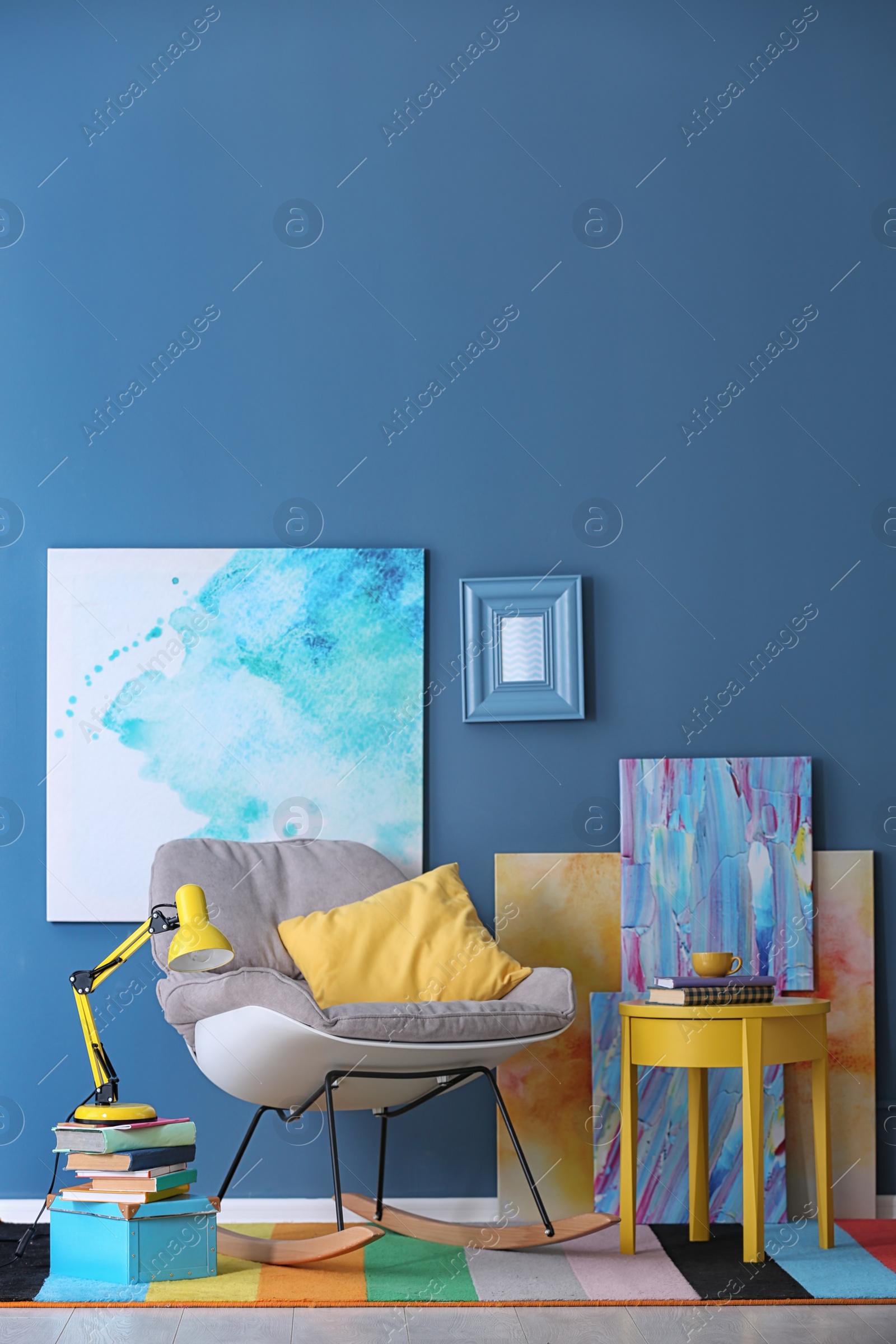 Photo of Modern room interior with comfortable rocking chair and rainbow carpet