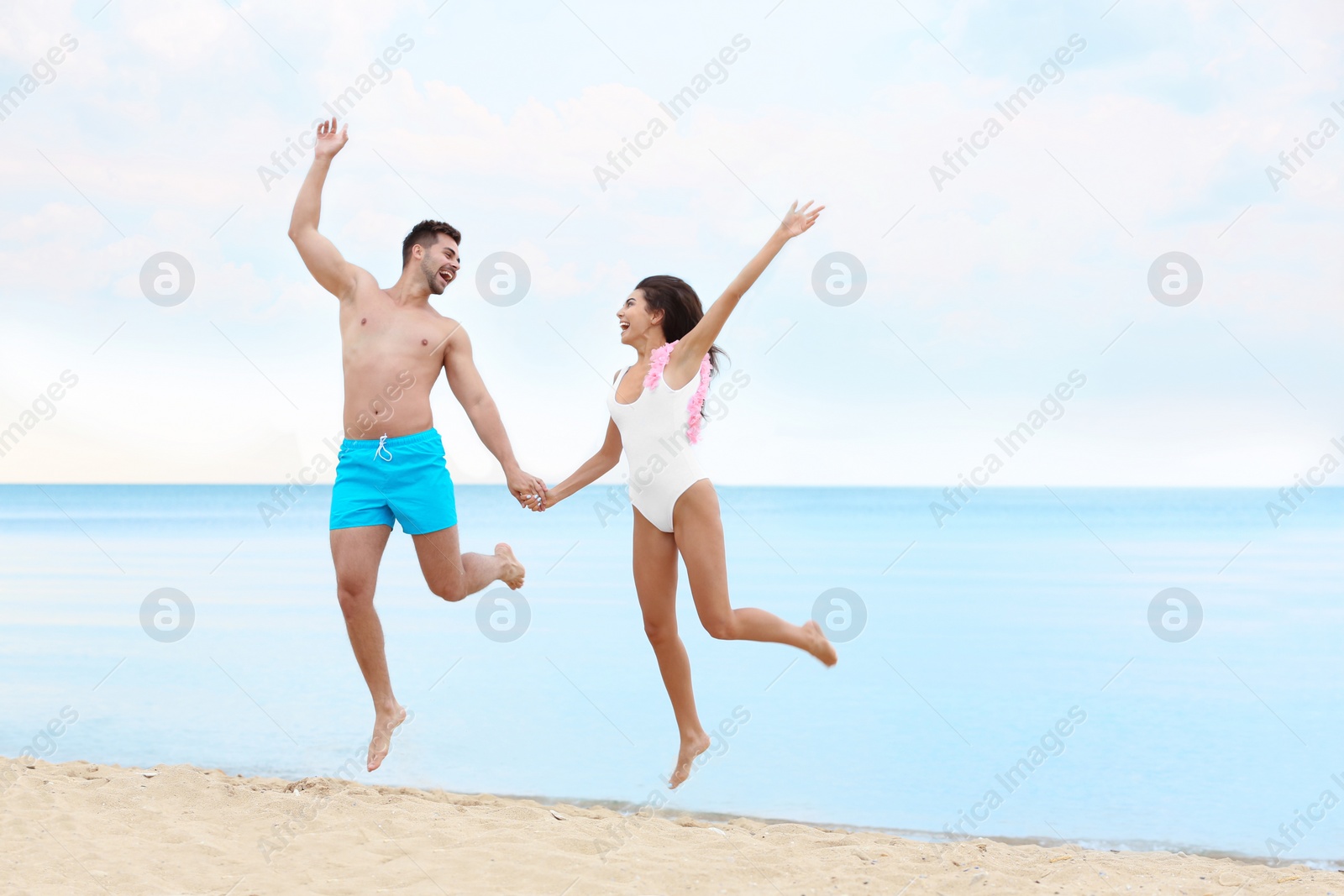 Photo of Happy young couple having fun together on beach near sea