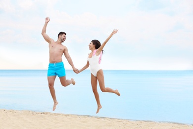 Photo of Happy young couple having fun together on beach near sea