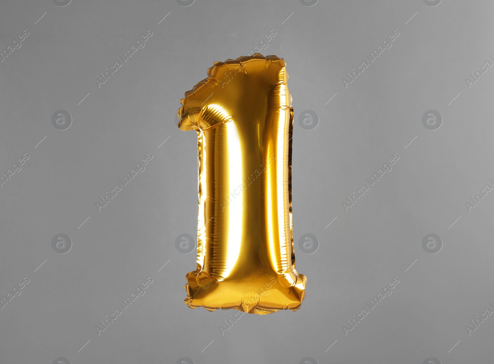 Photo of Golden number one balloon on grey background