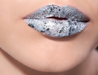 Photo of Beautiful young model with silver lips makeup, closeup