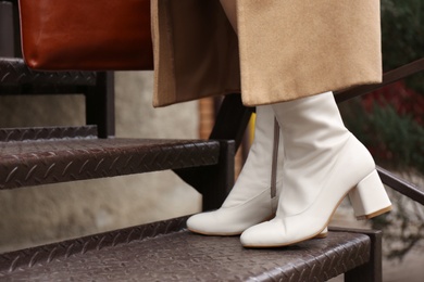Photo of Woman wearing stylish leather shoes on stairs outdoors, closeup