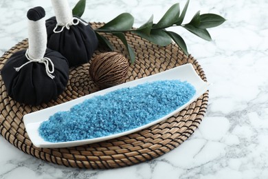 Photo of Composition with blue sea salt and herbal bags on white marble table