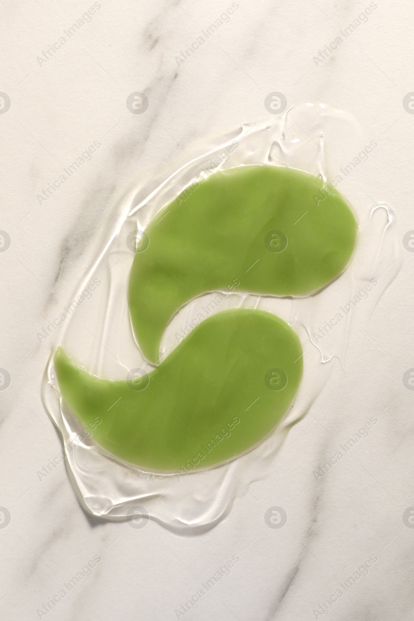 Photo of Green under eye patches with gel on white marble background, top view. Cosmetic product