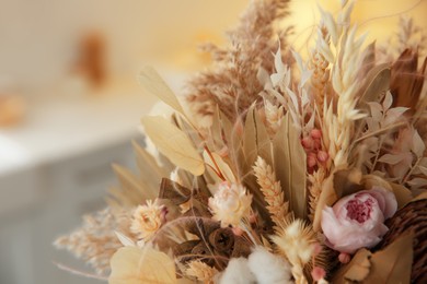 Photo of Bouquet of dry flowers and leaves on blurred background, closeup