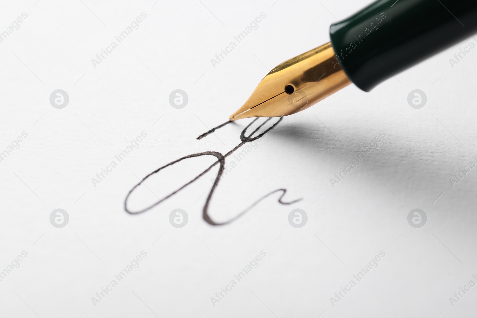Photo of Signing on sheet of paper with fountain pen, closeup