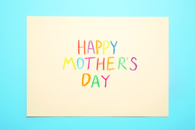 Photo of Greeting card with text Happy Mother's day on light blue background, top view