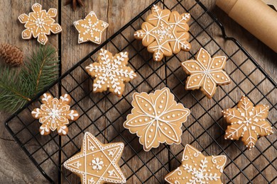 Tasty Christmas cookies, fir branches and cone on wooden table, flat lay