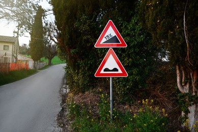 Photo of Traffic signs STEEP HILL UPWARDS and UNEVEN ROAD outdoors