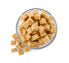 Glass bowl and brown sugar cubes on white background, top view