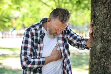 Mature man having heart attack in park