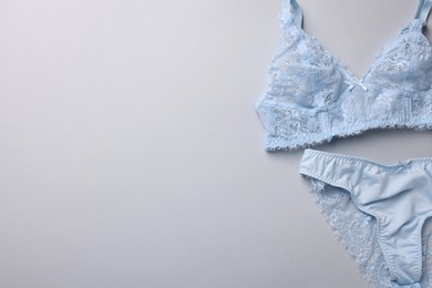 Photo of Light blue women's underwear on grey background, flat lay. Space for text