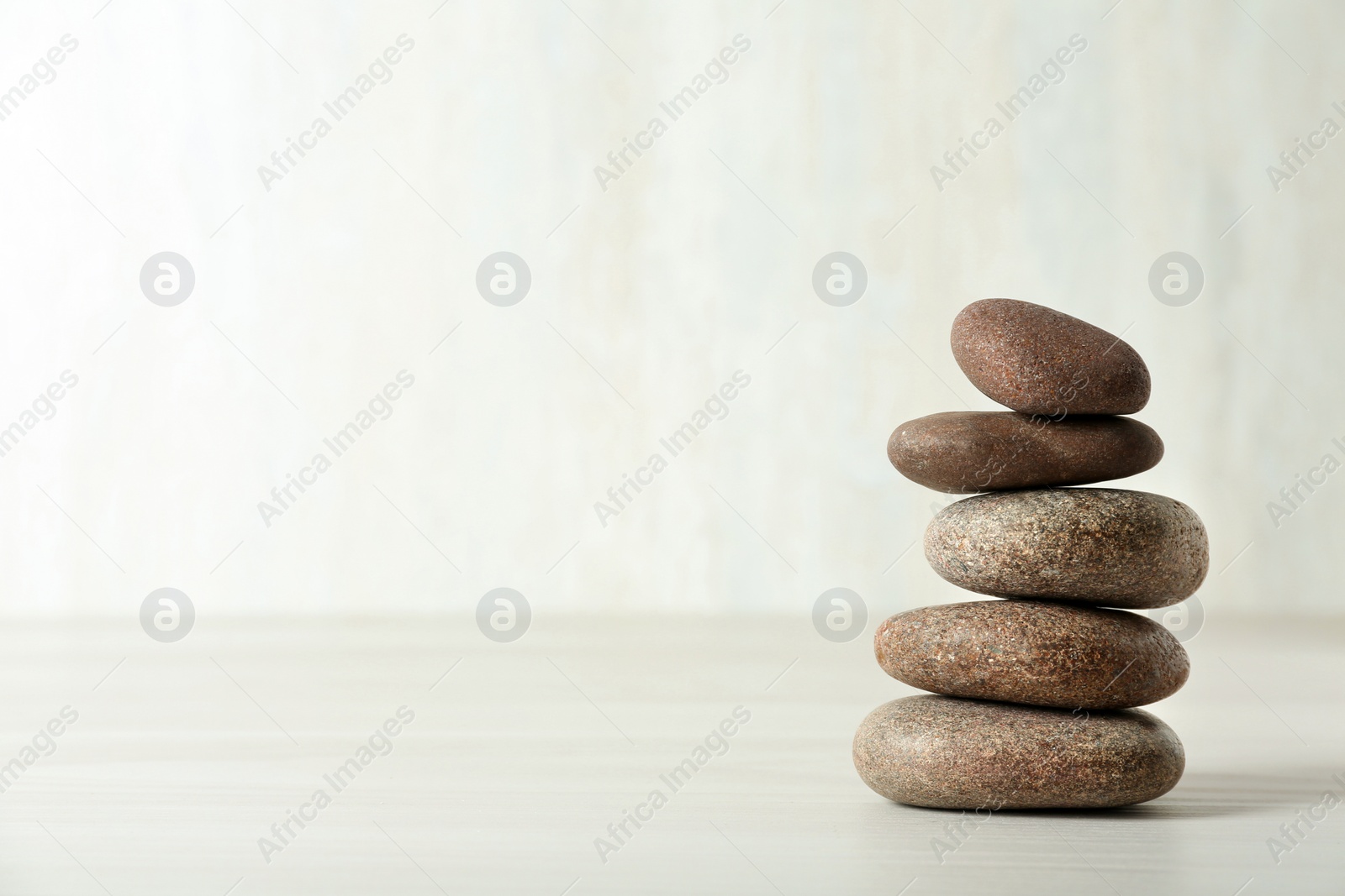 Photo of Stack of spa stones on table against white background, space for text