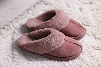 Pink soft slippers on carpet indoors, closeup