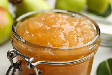 Photo of Delicious pear jam in glass jar, closeup