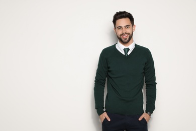 Portrait of handsome young man smiling on light background. Space for text