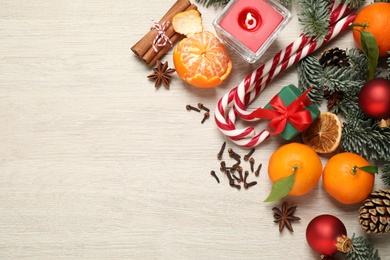 Flat lay Christmas composition with fresh tangerines on light wooden table. Space for text