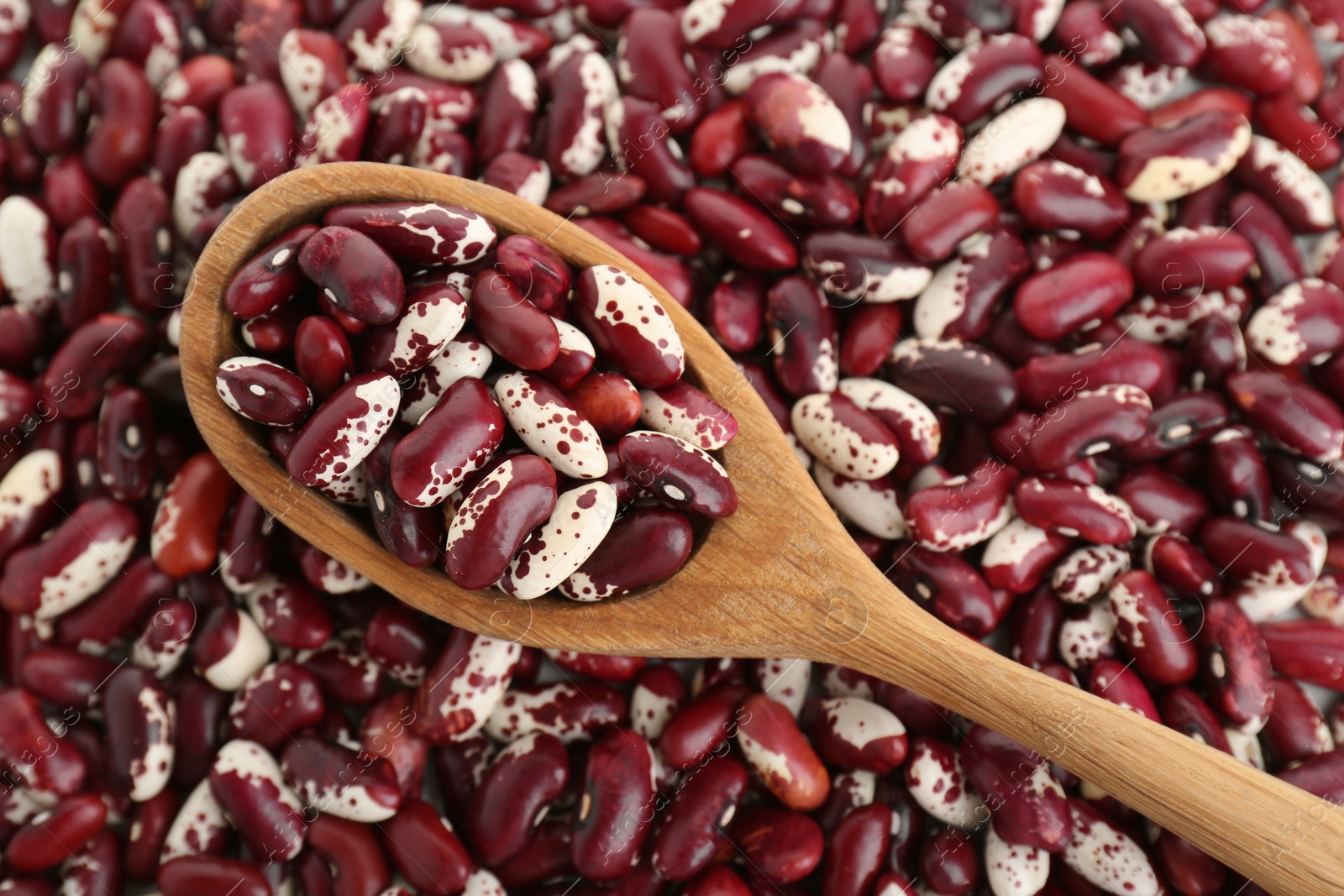 Photo of Wooden spoon on kidney beans, top view