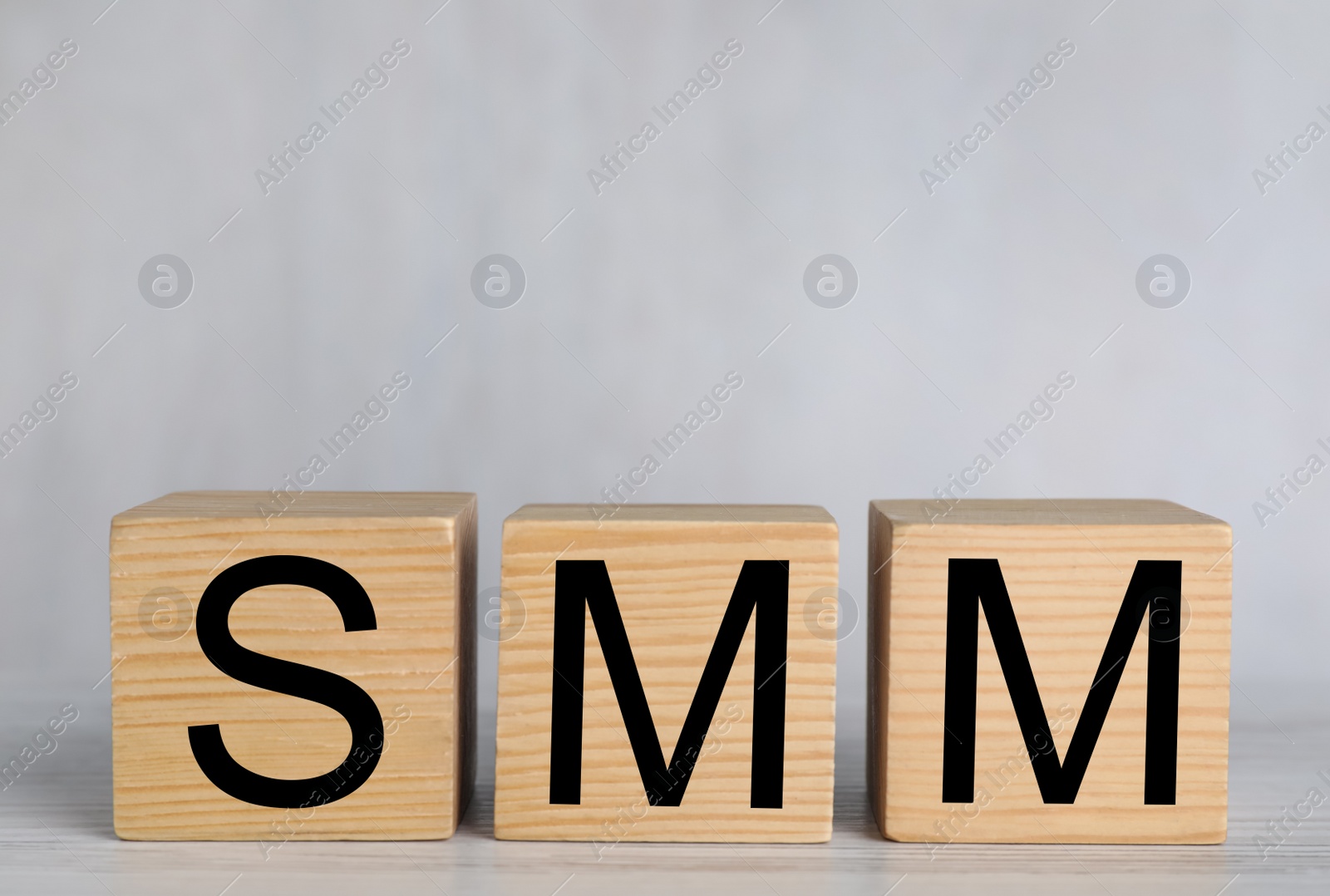 Photo of Cubes with abbreviation SMM (Social media marketing) on white wooden table