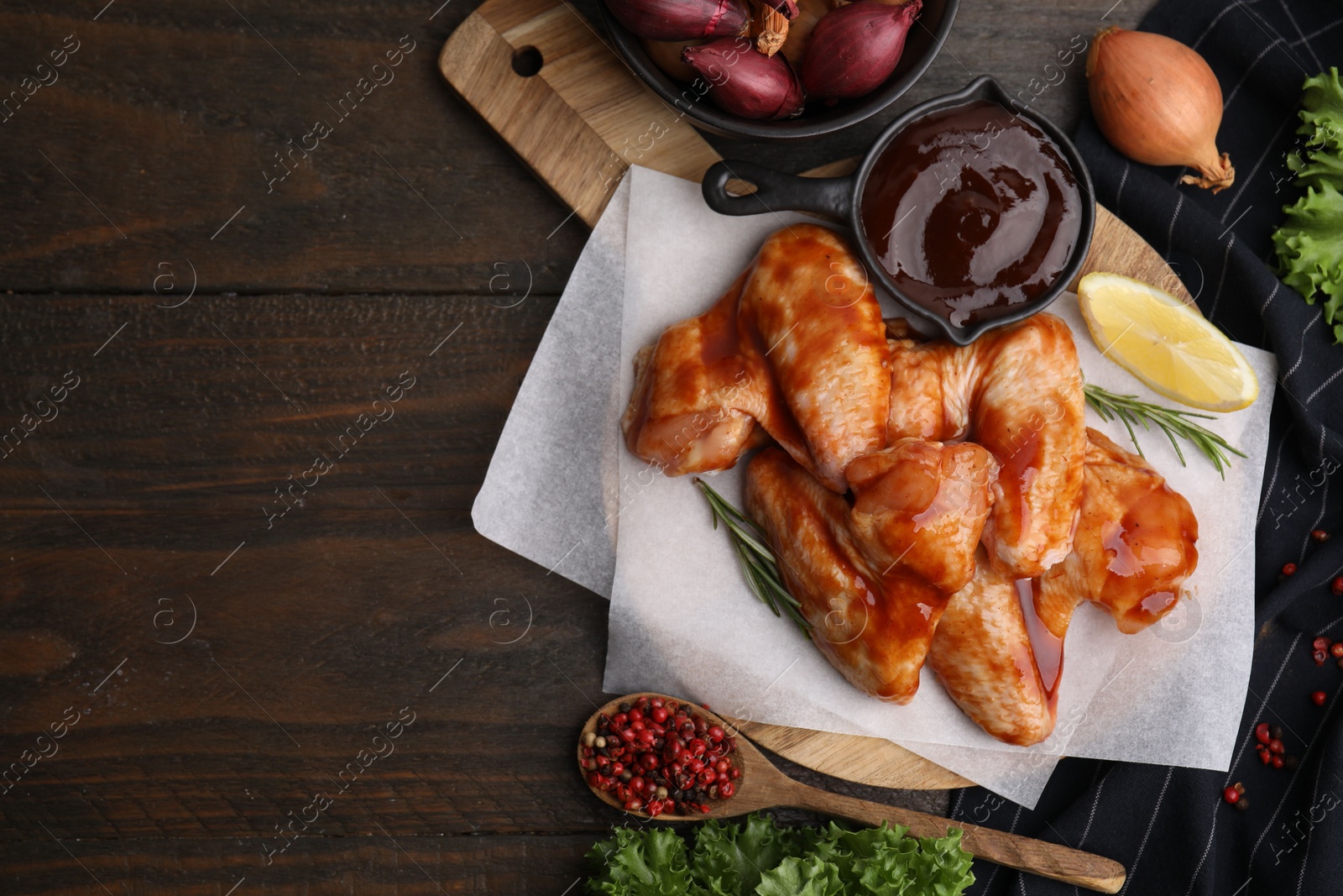 Photo of Flat lay composition with marinade, raw chicken wings and other products on wooden table. Space for text