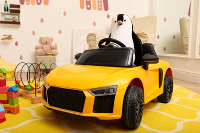 Photo of Child's electric car with toy penguin in playroom