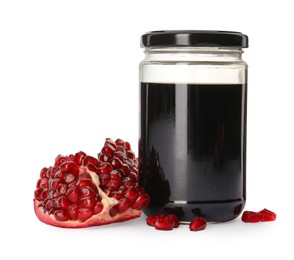 Glass jar of pomegranate sauce and fresh ripe fruit on white background