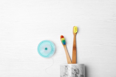 Photo of Flat lay composition with bamboo toothbrushes on white wooden background