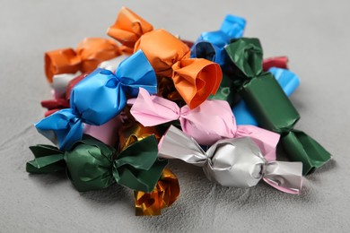 Photo of Candies in colorful wrappers on grey table