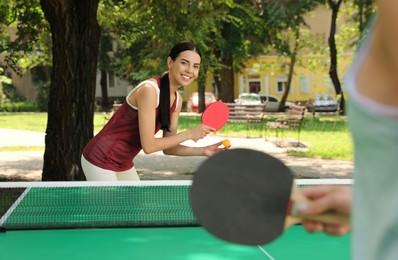 Young women playing ping pong in park