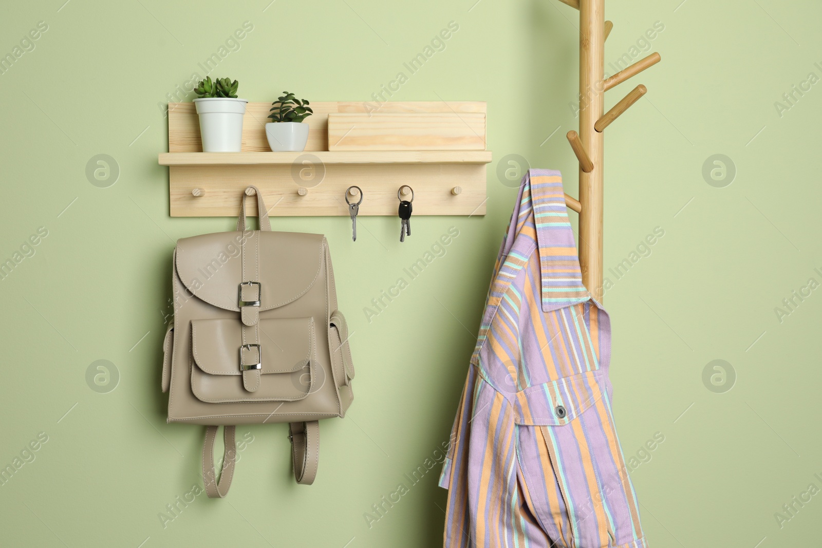 Photo of Wooden hanger for keys on light green wall