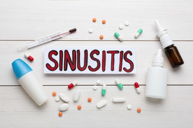 Card with word SINUSITIS, thermometer and different drugs on white wooden background, flat lay