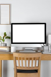 Photo of Home workplace. Computer, stationery and houseplants on wooden desk