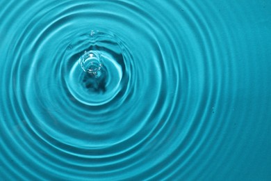 Photo of Rippled surface of clear water on light blue background, top view