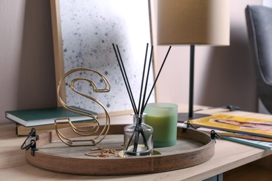 Photo of Stylish tray with different interior elements on wooden table in room