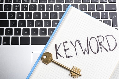 Photo of Notebook with word KEYWORD and key on laptop keyboard, top view