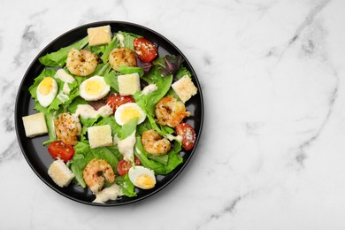 Delicious Caesar salad with shrimps on white marble table, top view. Space for text