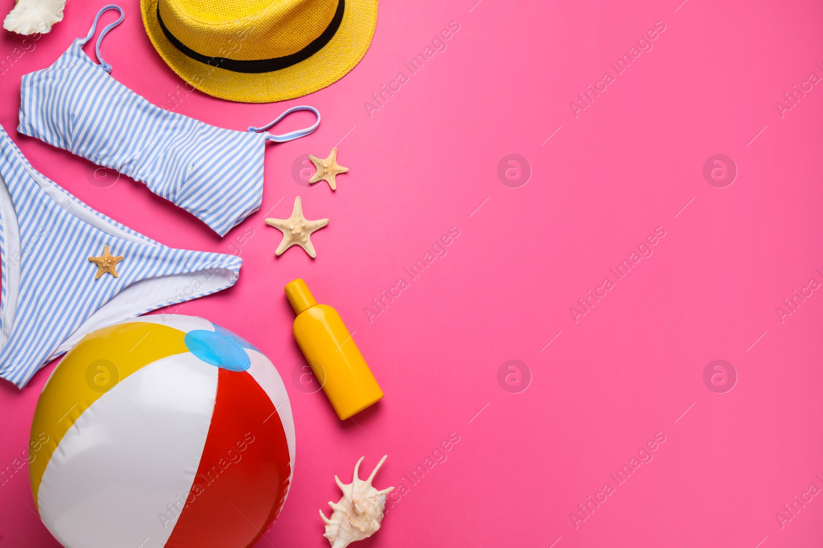 Photo of Flat lay composition with ball and beach objects on pink background, space for text