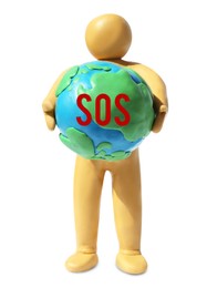 Image of Yellow plasticine human figure holding planet with word SOS isolated on white