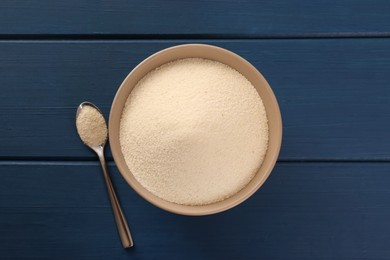 Photo of Uncooked organic semolina on blue wooden table, flat lay